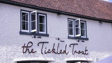 Een gebouw met daarop het bord 'the Tickled Trout'.