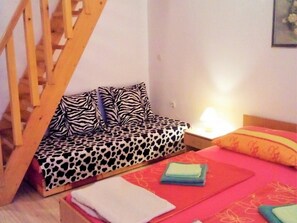 A room with a bed, a wooden bench, a nightstand, and a staircase. - Apartments Anto (Pula)