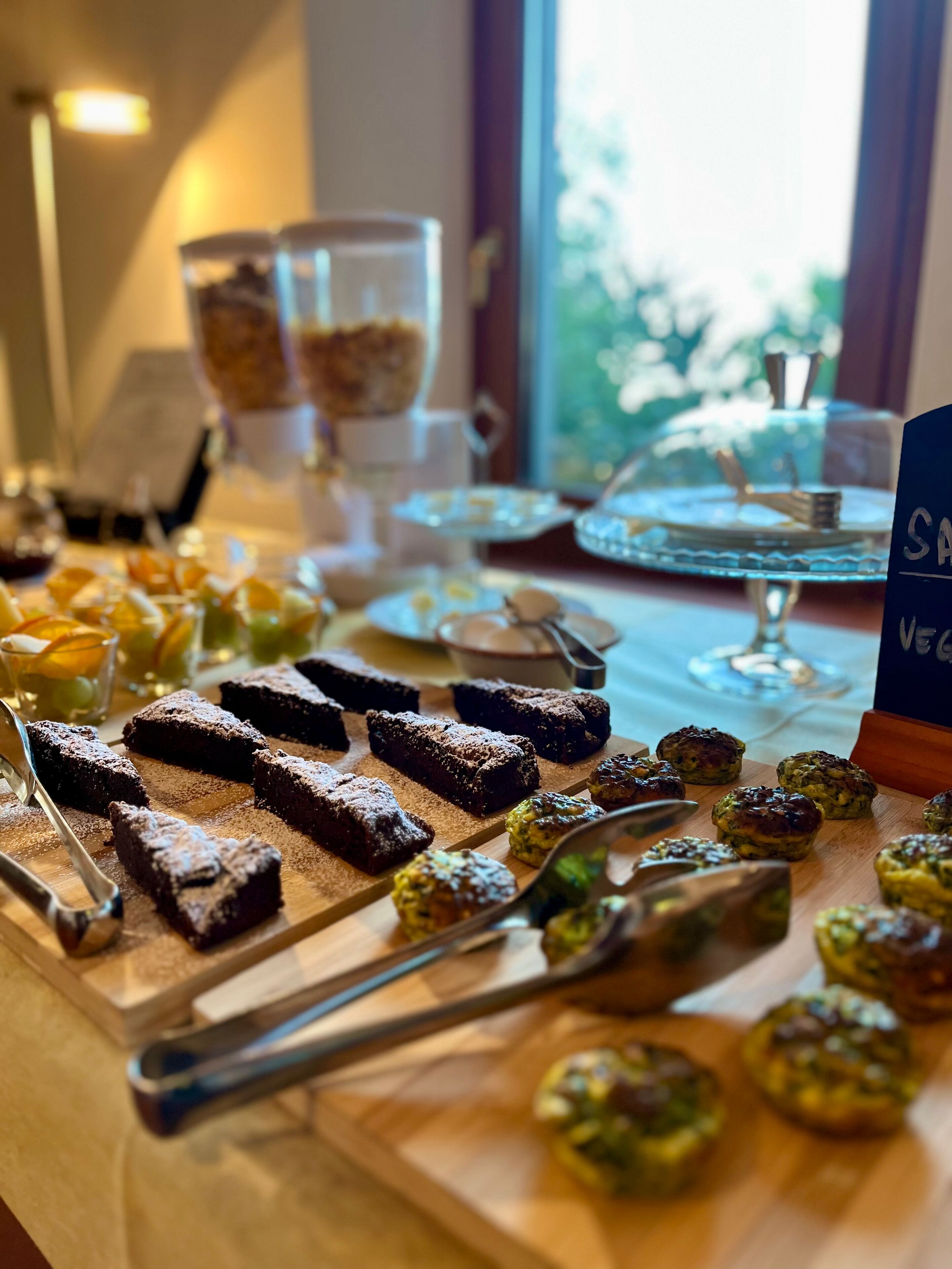 A buffet table with various desserts and a sign indicating vegan options.