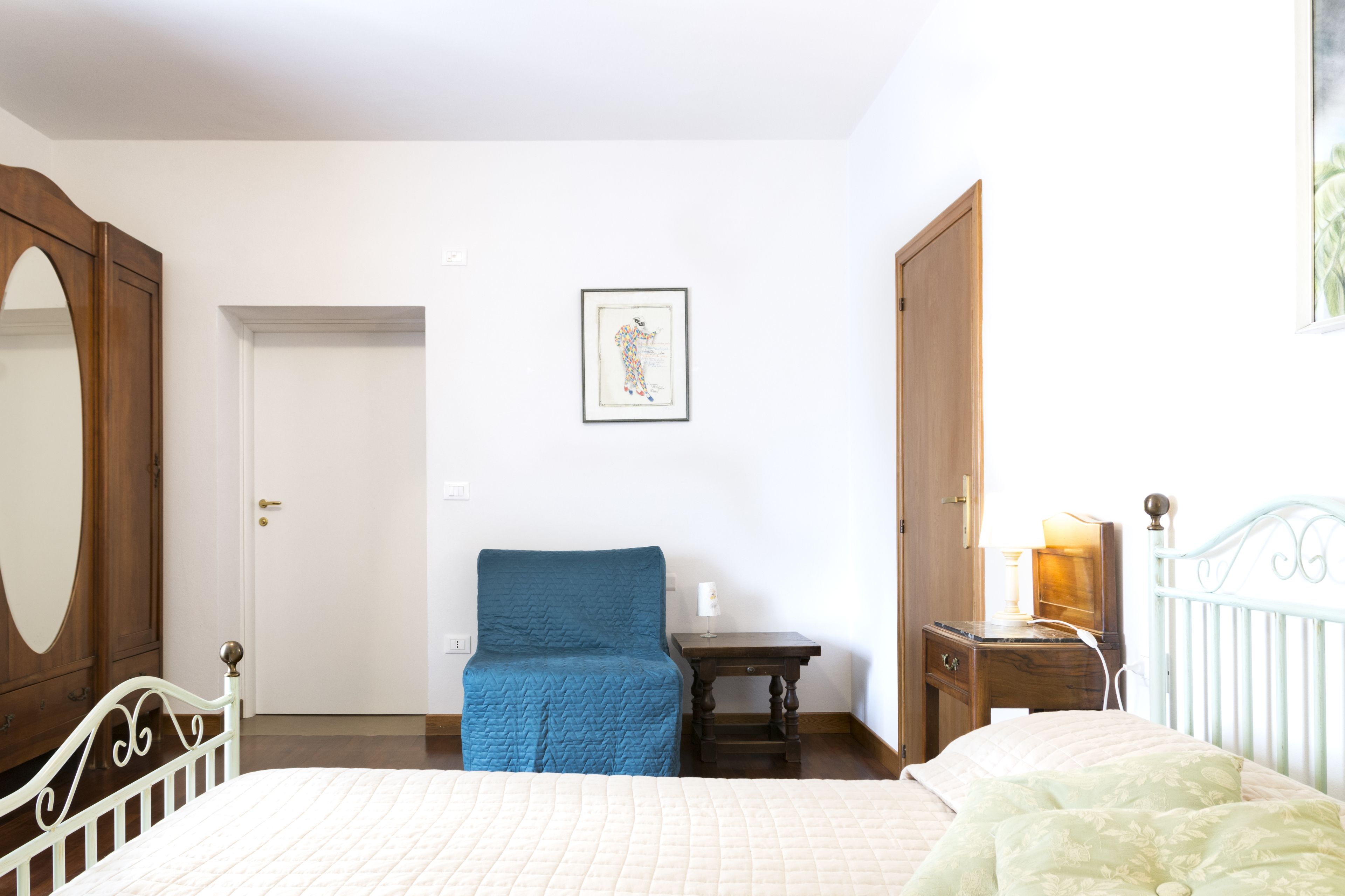 Ein Schlafzimmer mit Bett, Stuhl, Schreibtisch und Kommode.