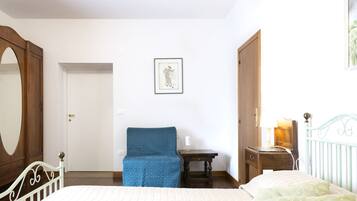 Ein Schlafzimmer mit Bett, Stuhl, Schreibtisch und Kommode.