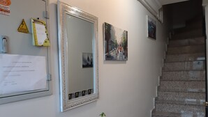 A staircase with a handrail, a wall-mounted mirror, and a framed picture. - Burak Apart Otel (Istanbul)