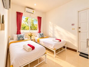 A hotel room with two beds, a window with curtains, an air conditioning unit, and a 'No Smoking' sign. - Chalong 4BR Private Pool Villa | Near Big Buddha | Sleeps 10 (Tambon Chalong)