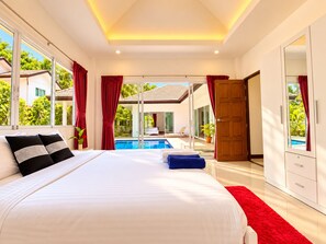 A bedroom with a large bed, a view of a swimming pool, and a door leading to a balcony. - Chalong 4BR Private Pool Villa | Near Big Buddha | Sleeps 10 (Tambon Chalong)