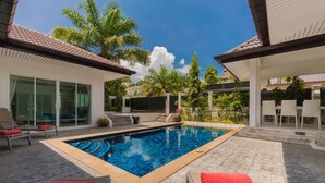 A swimming pool with lounge chairs and a covered patio area. - Chalong 4BR Private Pool Villa | Near Big Buddha | Sleeps 10 (Tambon Chalong)
