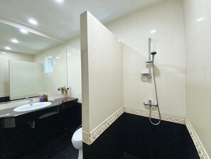 A bathroom with a black and white tiled floor, a white sink, a mirror, and a shower.