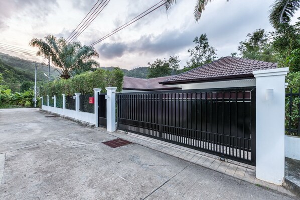 A gated property with a concrete driveway and a metal fence.