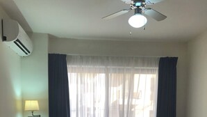 A living room with two sofas, a coffee table, a ceiling fan, and a window with curtains. - Private Apartment... (FREE WIFI ) (st pauls bay)