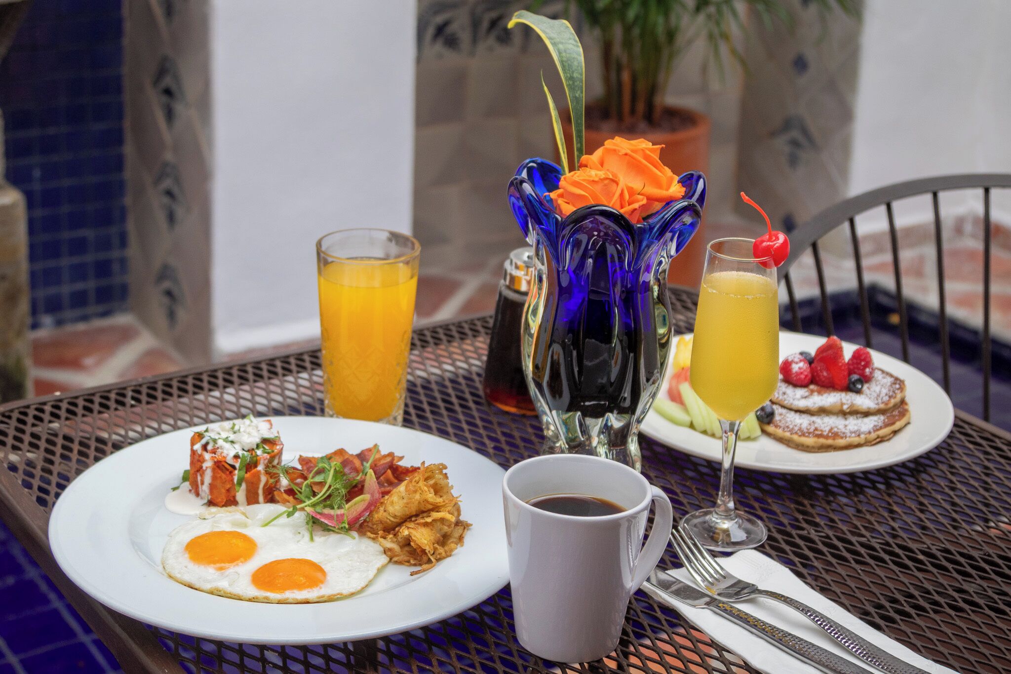 Una escena de desayuno con platos de comida, una taza de café y un vaso de jugo de naranja.