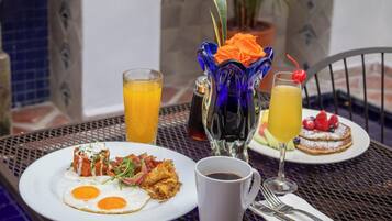 Una escena de desayuno con platos de comida, una taza de café y un vaso de jugo de naranja.