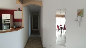 A narrow hallway with a kitchen on the left and a dining area on the right. - Soleil single-storey villa with 8/4 saltwater swimming pool, secure, fenced garden  (Lagorce)