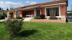 A two-story house with a tiled roof, a covered patio, and a lawn. - Soleil single-storey villa with 8/4 saltwater swimming pool, secure, fenced garden  (Lagorce)