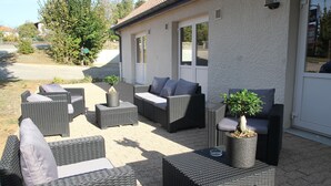 An outdoor seating area with wicker furniture and potted plants. - Doubs Hotel - Hostel (Ecole-Valentin)