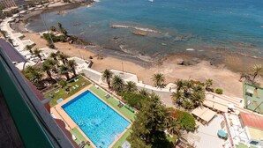 Zona de piscina con vista a la playa y al océano.
