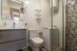 A modern bathroom with a toilet, bidet, and shower.