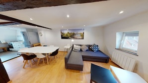A modern kitchen with a dining area, a sofa, and a view of a cityscape. - spacious duplex near petite france up to 4 (Strasbourg)