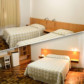 Quarto com duas camas, uma escrivaninha e um guarda-roupa.