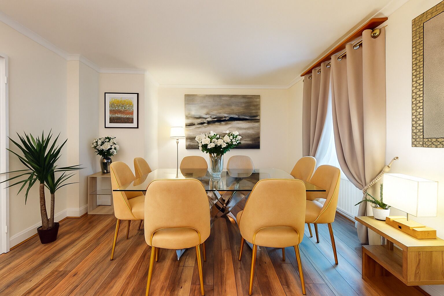 A dining area with a glass table, four chairs, a vase of flowers, and a painting on the wall.