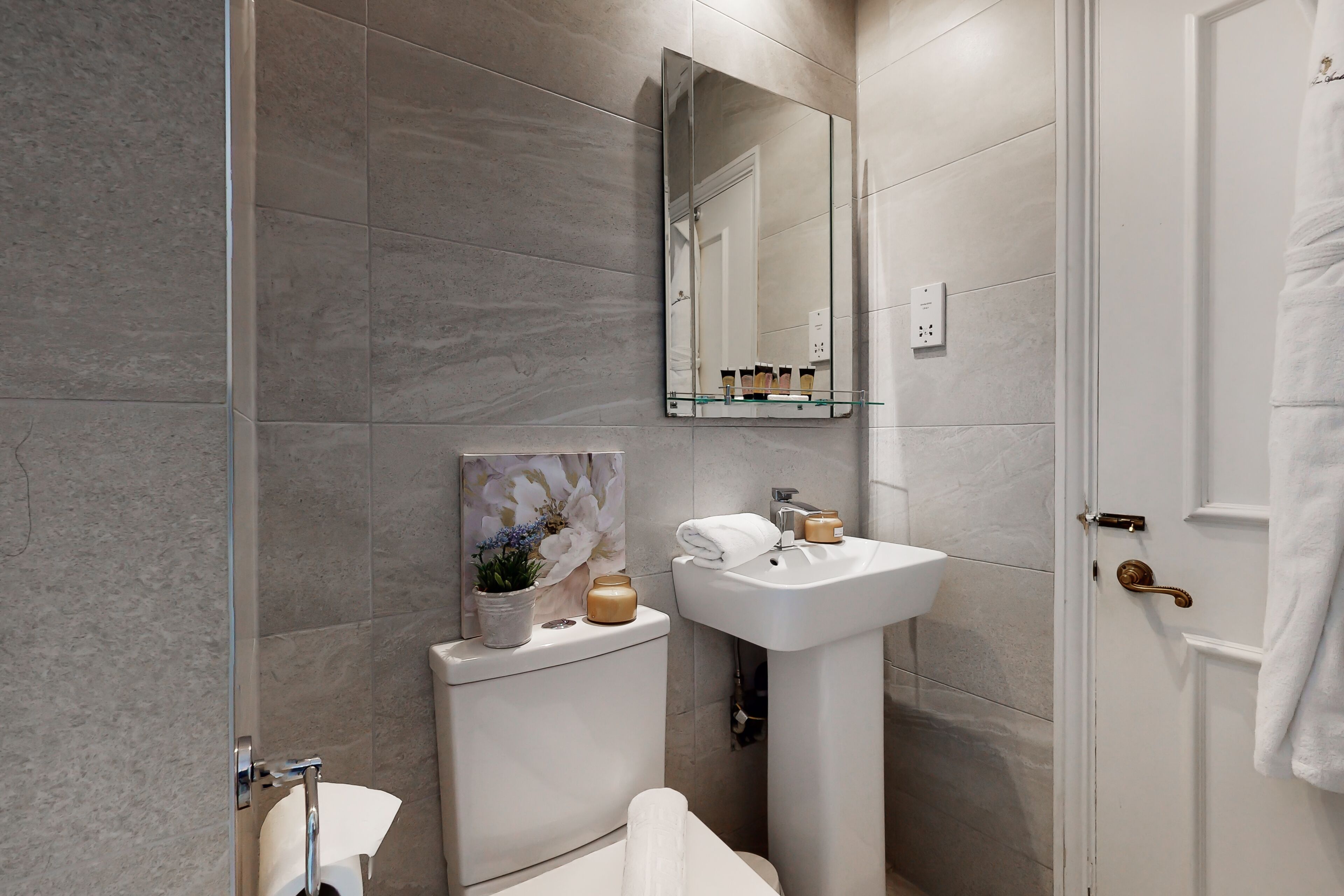 A bathroom with a toilet, sink, and shower.
