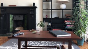Un salón con chimenea, una mesa de centro de madera, una estantería y una planta en maceta.