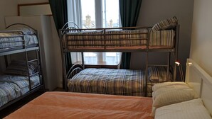 Una habitación con literas, un escritorio y una ventana con cortinas.