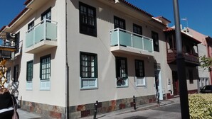 Un edificio de dos pisos con un balcón en el segundo piso, un letrero que dice 