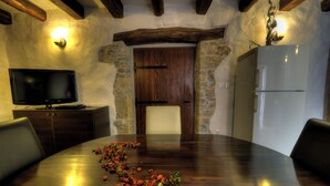 A conference room with a wooden table, chairs, a television, and a refrigerator. - Traditional Stone House 3 (Buzet)