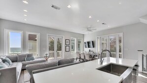 A modern kitchen with a large island, white cabinetry, and a built-in oven. - Aria Del Mare - Beach House with Ocean Views & Private Pool Area (Miramar Beach)