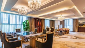 A spacious hotel room with a large dining area, a sofa set, and a chandelier. - Zhongjia Palace Hot Spring Hotel (Beijing)