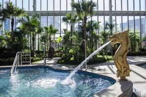 A pool with a water feature and a decorative sculpture.