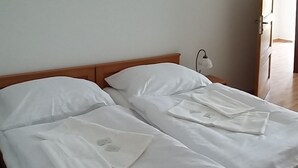 A double bed with white linens and a wooden headboard. There is a bedside table with a lamp on the left side. - Farm Kundratice (Kundratice)