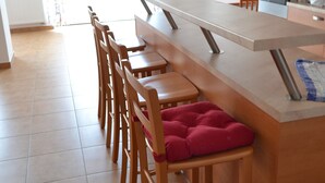 A modern kitchen with a central island, wooden chairs, and a dining table. - Farm Kundratice (Kundratice)