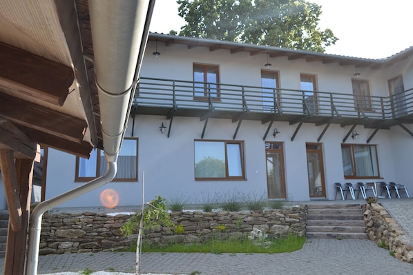 A two-story building with a stone wall and steps leading to the entrance. - Farm Kundratice (Kundratice)