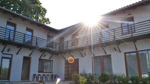 A two-story building with a balcony, a stone staircase, and a garden area. - Farm Kundratice (Kundratice)
