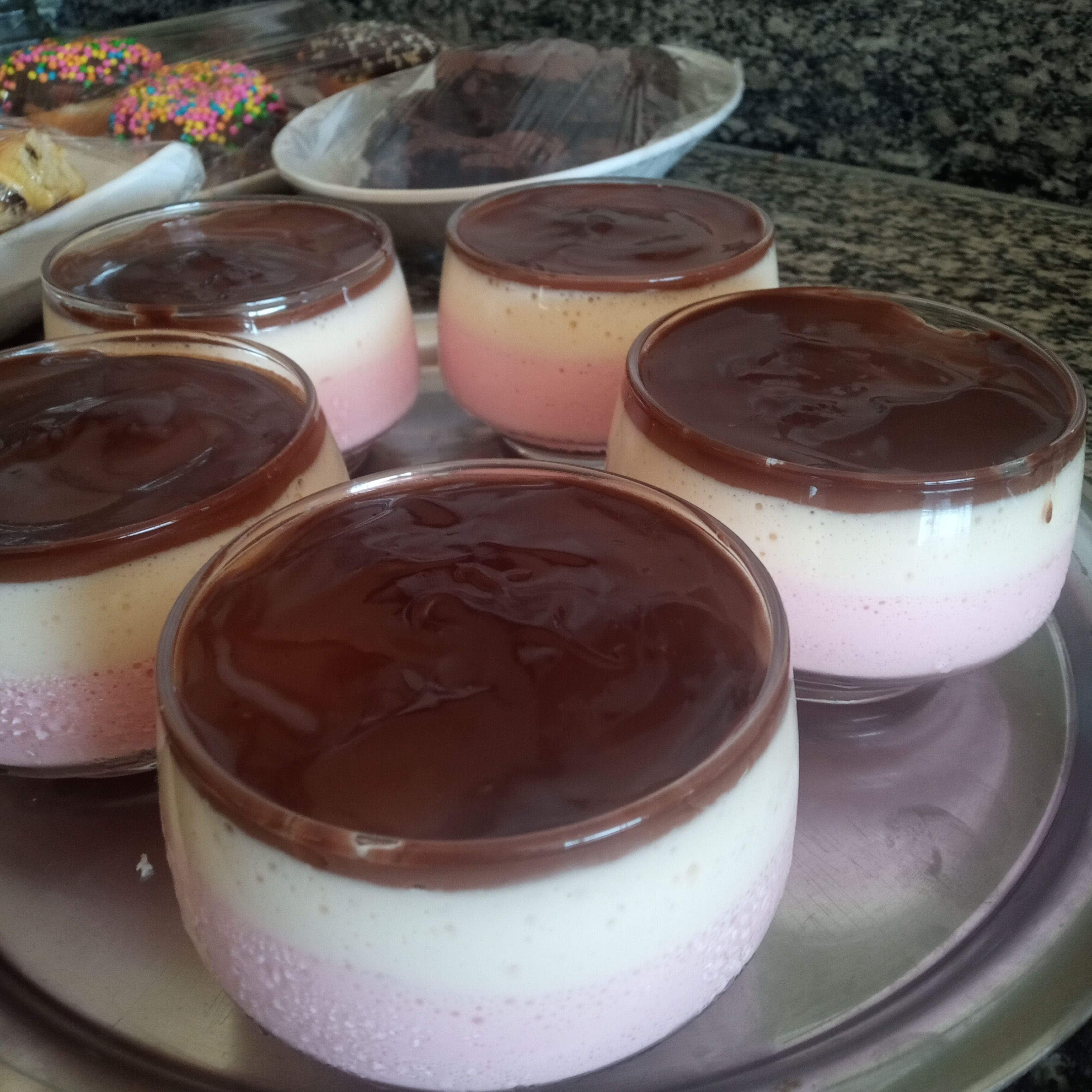 A tray of layered desserts with a chocolate topping.