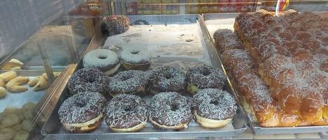 A display case with various pastries including donuts and a large rectangular pastry.