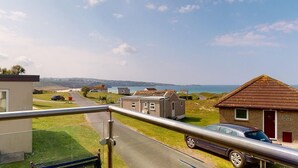 Un quartier résidentiel situé sur la côte, avec des maisons, une route et une vue sur la mer.