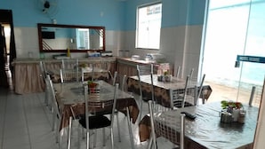 A dining area with tables and chairs, a large mirror, and a window with a view.
