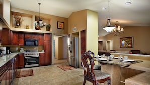 A spacious kitchen with granite countertops, stainless steel appliances, and a dining area with a marble island. - Windrose McCormick Ranch (Scottsdale)