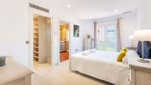 A bedroom with a bed, a desk, a wardrobe, and a window with curtains. - Ohana1 Luxury villa. (Málaga)