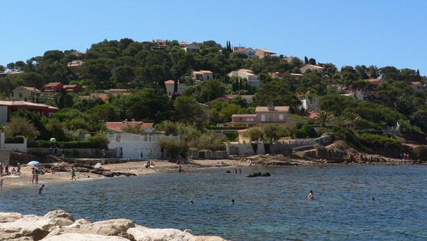 A coastal town with houses on a hillside, a beach, and clear blue water. - T2 by the sea, 150 m to the beach/sea, TOPP prices, FREE: WLAN, pool, tennis (Le Pradet)