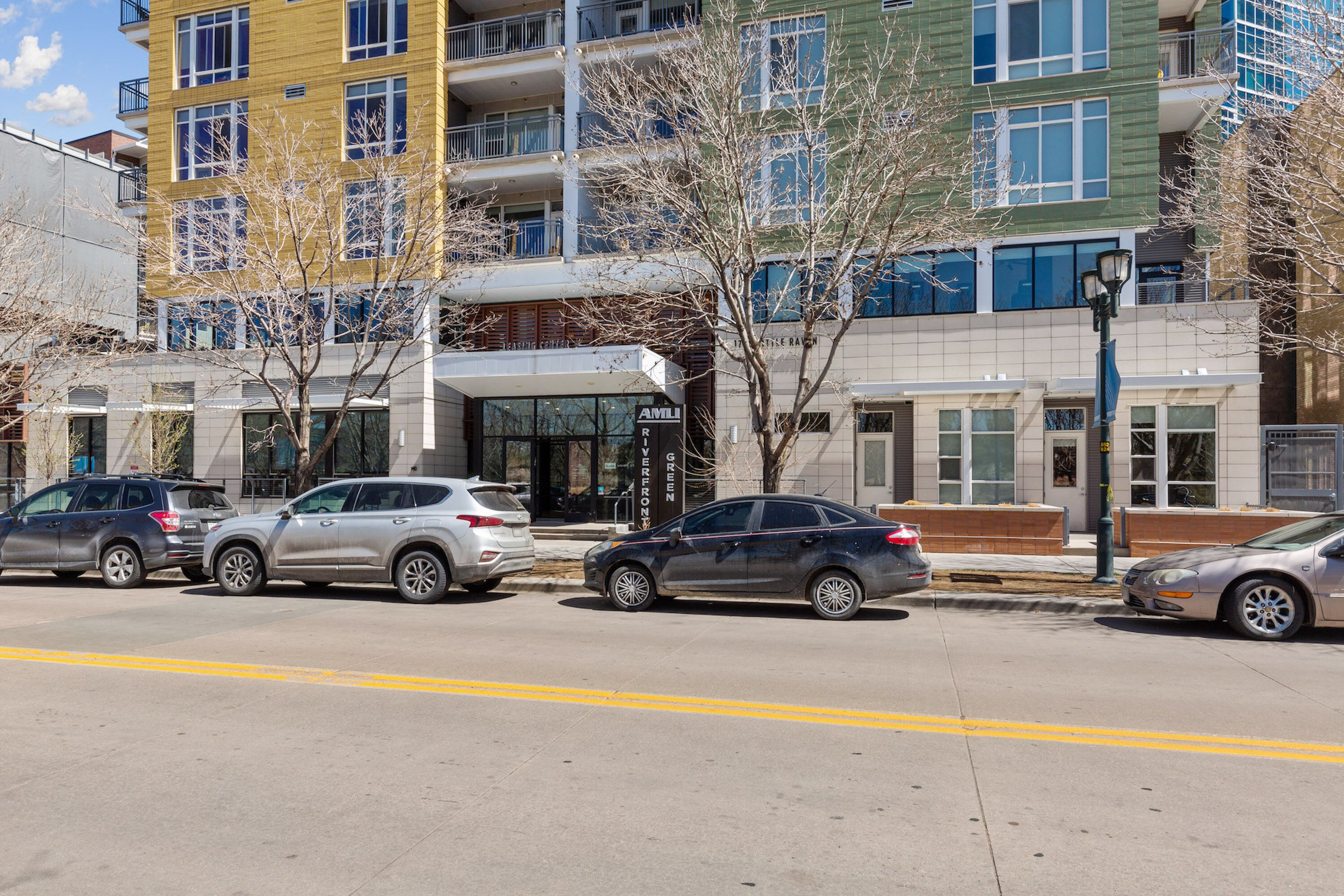 A multi-story building with a modern architectural design, featuring balconies and large windows.