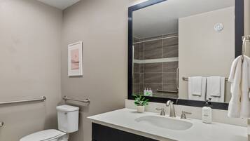 Un baño moderno con un lavabo blanco, un espejo grande y un inodoro.