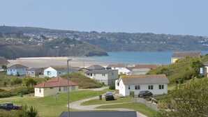 Un quartier résidentiel situé sur la côte, avec des maisons, une plage et une vue dégagée sur la mer.