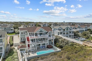 A multi-story residential building with a swimming pool, balconies, and a deck area. - 4099 - 3-2-1 Relax - Duck Oceanfront Retreat | Sleeps 22, Pool, Hot Tub (Duck)