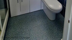 Ein Badezimmer mit einem weißen Waschbecken, einer Toilette und einem Spiegel über dem Waschbecken.