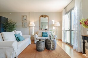 A living room with a sofa, two side tables, a floor lamp, and a large mirror.