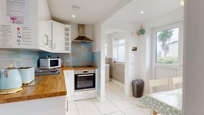 Una cocina moderna con armarios blancos, microondas, horno y tostadora.