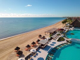 On the beach, white sand, sun loungers, beach umbrellas