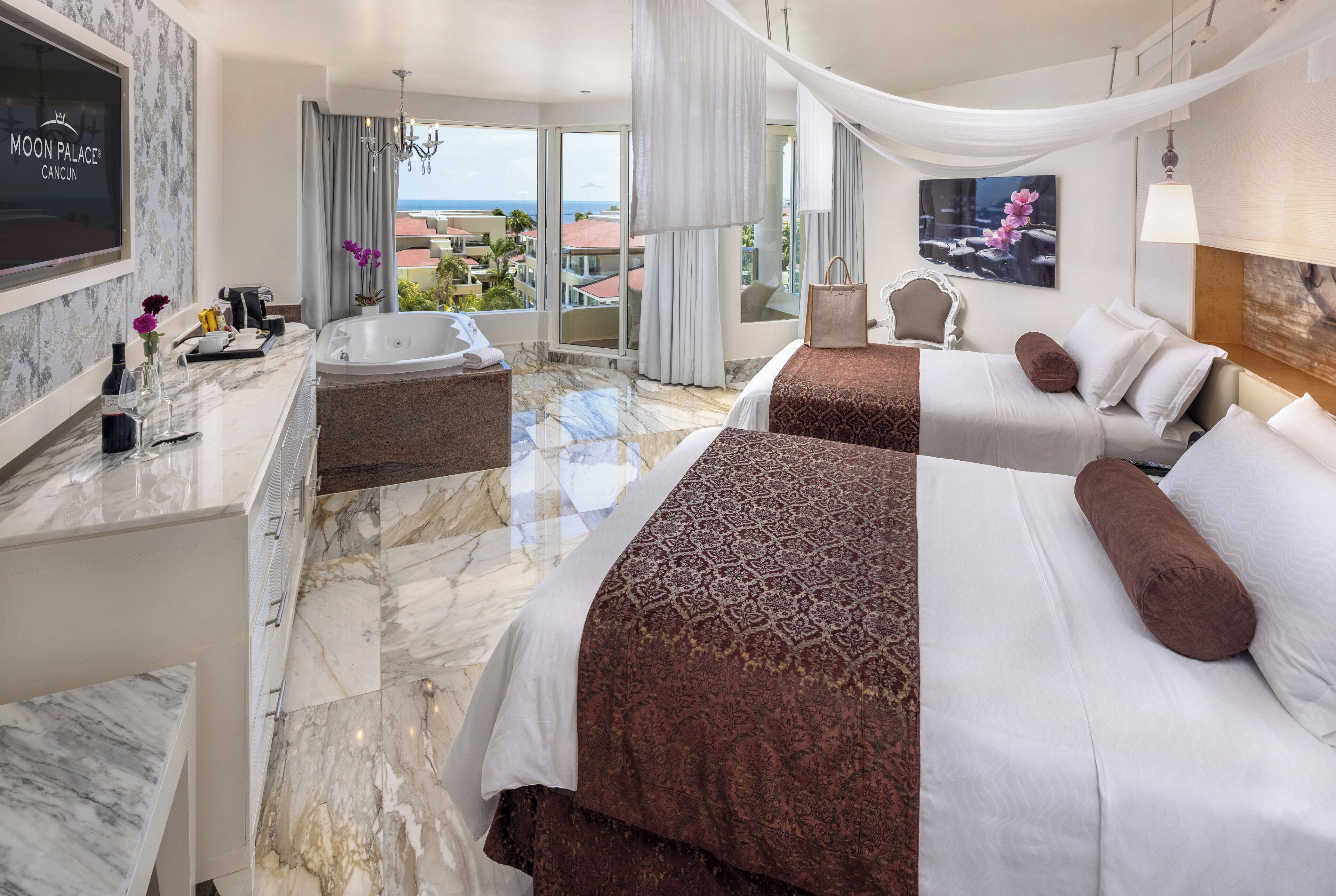 A hotel room with a large bed, a separate sitting area with a view, a bathtub, and a TV.